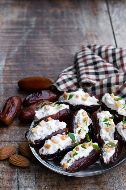 istock Dates stuffed with cream cheese and almonds on wooden table 1135174865
