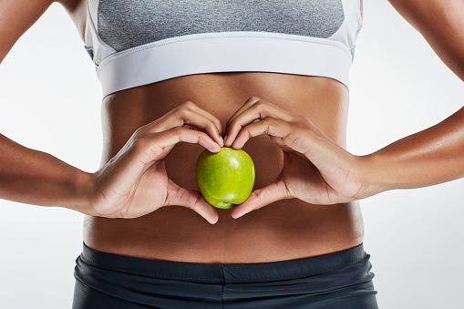 Cropped shot of a sporty young woman holding an apple