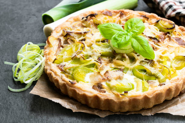 istock Leek tart with bacon and cheese on black stone background 1135175001