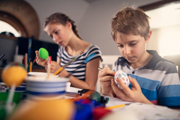 istock Brother and sister painting Easter eggs 1135175186