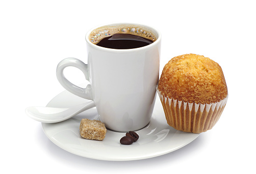 Cup of hot coffee and cupcake on white