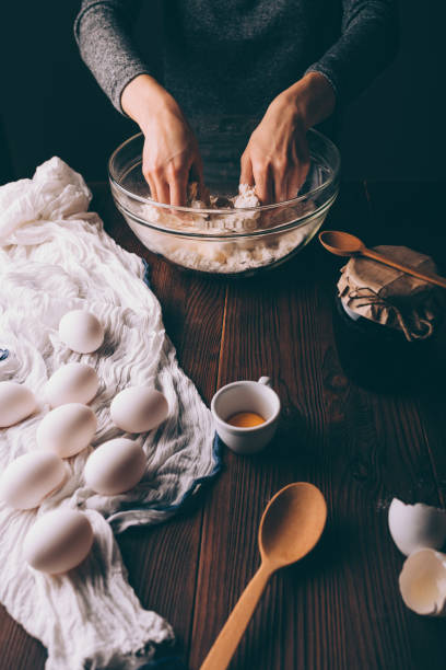 istock Female's hands kneading dough in big bowl 1135179554