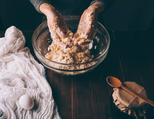 istock Woman's hands kneading dough in big bowl 1135179555