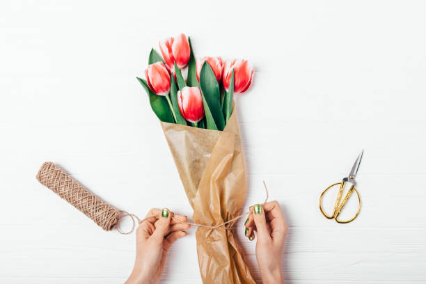 istock Woman's hands packing bouquet of fresh red tulip 1135179631