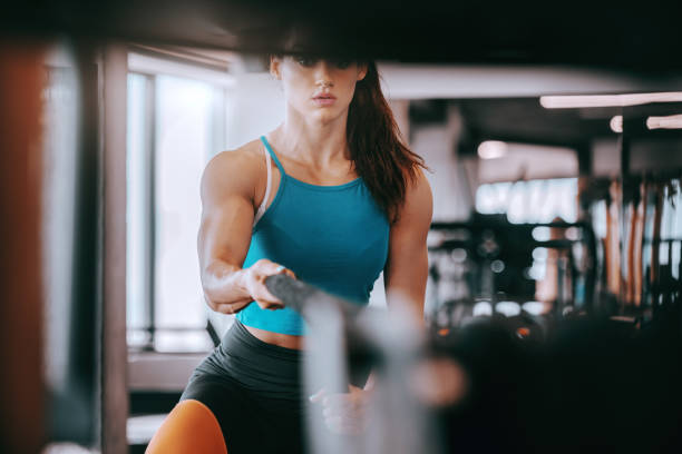 istock Young Caucasian female bodybuilder pulling rope in gym. The question isn't can you, the question is will you. 1135180380