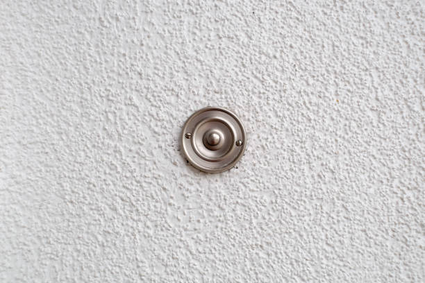 Stainless steel doorbell on a white wall