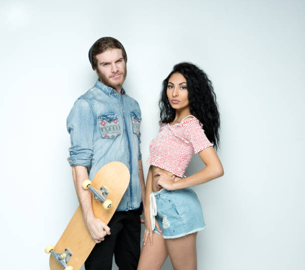 istock Cute young hip couple standing in front of white wall 1135181547