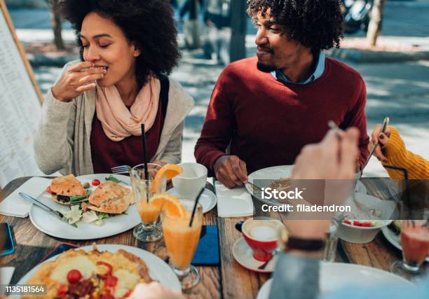 Disfrutando De La Comida Al Aire Libre Foto de stock y más banco de imágenes de Brunch - Brunch, Restaurante, Amistad