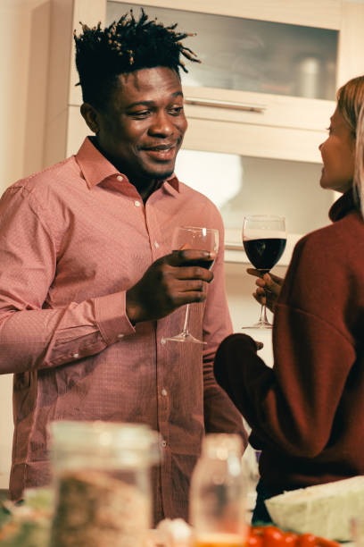 istock Smiling man looking at his girlfriend while drinking wine with her 1135181846