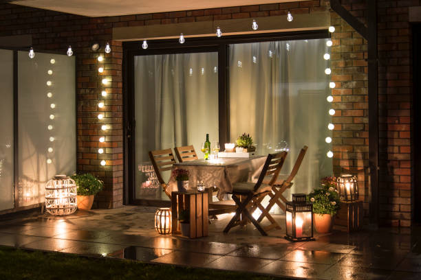 Summer evenig terrace with candles, wine and lights Summer evenig terrace with candles, wine and lights, wet pavements garden party stock pictures, royalty-free photos & images