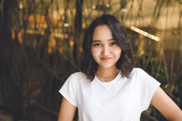 menina asiática optimista alegre em um t-shirt branco, sorrindo - t shirt child white portrait - fotografias e filmes do acervo