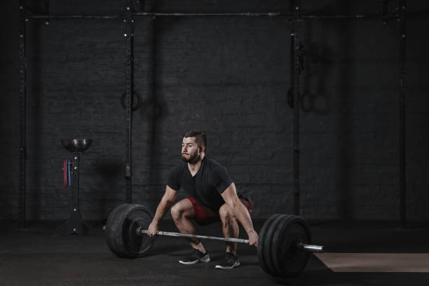 istock Young athlete doing deadlift exercise with heavy barbell at the gym 1135187955