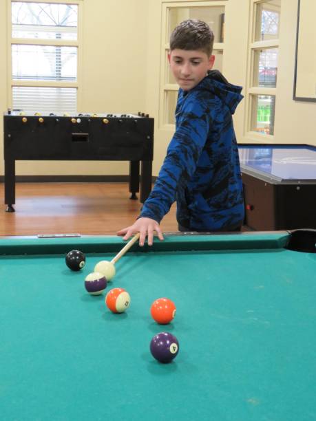 мальчик играет бассейн (бильярд) - child sport playing pool game стоковые фото и изображения