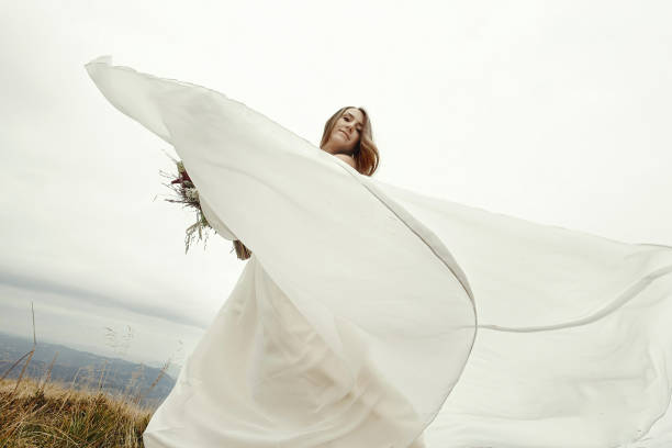 istock gorgeous bride dancing and having fun holding dress, boho wedding, luxury ceremony at mountains 1135191812