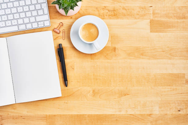 istock Wood office desk table with blank notebook, pen, computer and coffee 1135193099