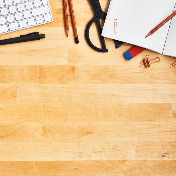istock Wooden office desk table with blank notebook, computer, and supplies. 1135193122