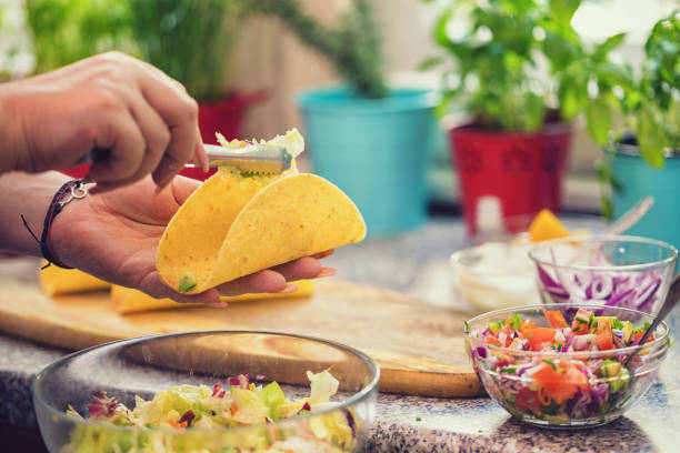 Preparing tacos with spicy avocado salad and shrimps Young woman preparing Mexican tacos with spicy avocado salad and shrimps mexican culture food mexican cuisine fajita stock pictures, royalty-free photos & images