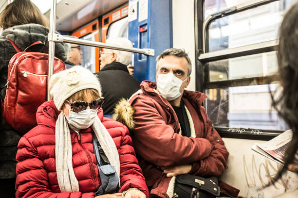 matured man and woman wearing protective mask in train. - swine flu fotos imagens e fotografias de stock