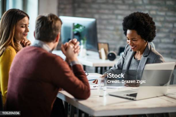 Cheerful African American Financial Advisor On A Meeting With A Couple Stock Photo - Download Image Now