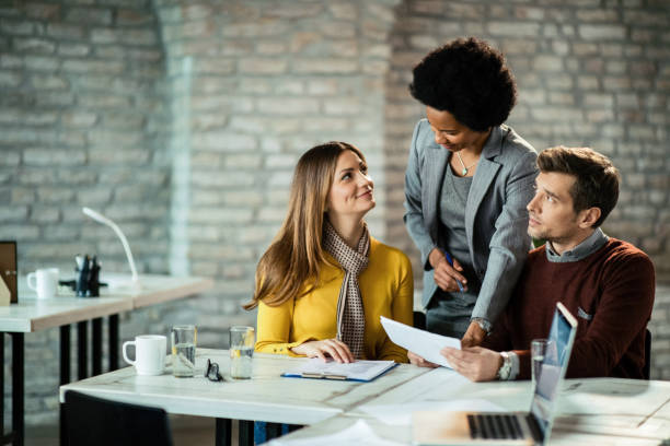 istock Couple going through paperwork with their financial advisor in the office. 1135206832