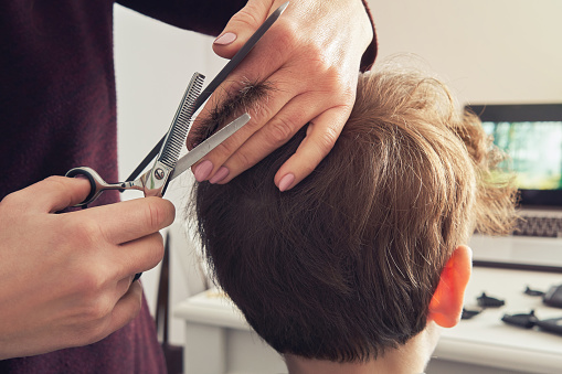 Mom Makes A New Haircut With Scissors And A Comb To Her Sons House A Woman  Shears The Boys Hair With Scissors Stock Photo - Download Image Now - iStock