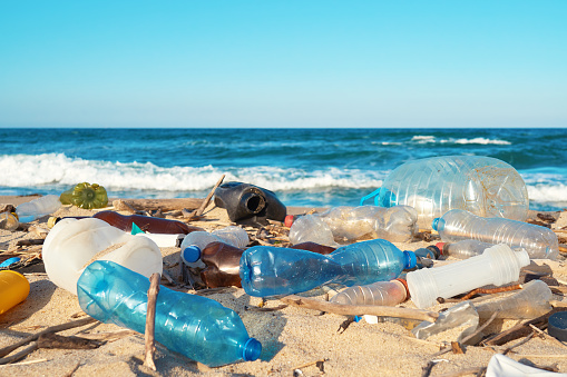 Derramó basura en la playa de la gran ciudad. Botellas de plástico sucias usadas vacías. Botellas de plástico sucias usadas vacías. Sucia orilla arenosa del mar negro. Contaminación ambiental. Problema ecológico photo