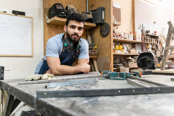 istock Latin american male construction worker leaning his arms on table while facing camera 1135209224