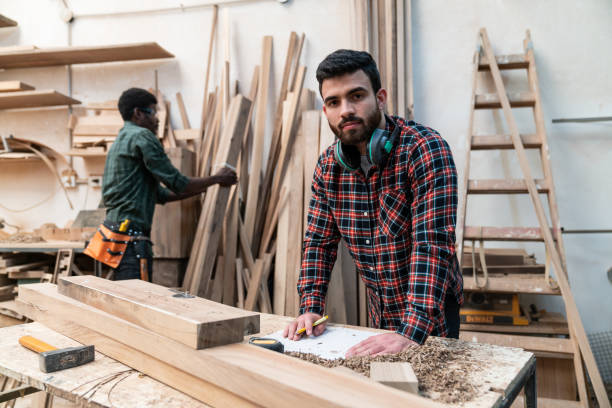 istock Handsome latin american carpenter facing camera while leaning on table at the carpentry 1135209239