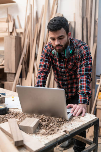 istock Focused latin american young carpenter checking designs on laptop 1135209250