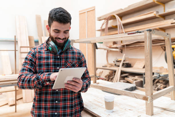 istock Young male carpenter taking a break looking at his social media on tablet while enjoying a coffee to go 1135209274