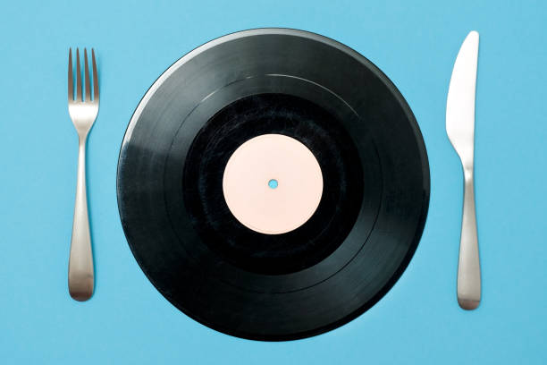 istock vinyl record with fork and knife on a blue background. Good taste in music 1135210079