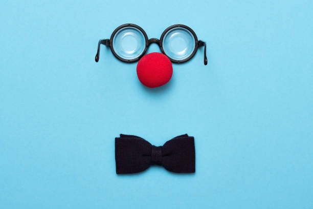 śmieszne okulary, czerwony nos klauna i krawat leżą na kolorowym tle, jak twarz. - eyeware zdjęcia i obrazy z banku zdjęć