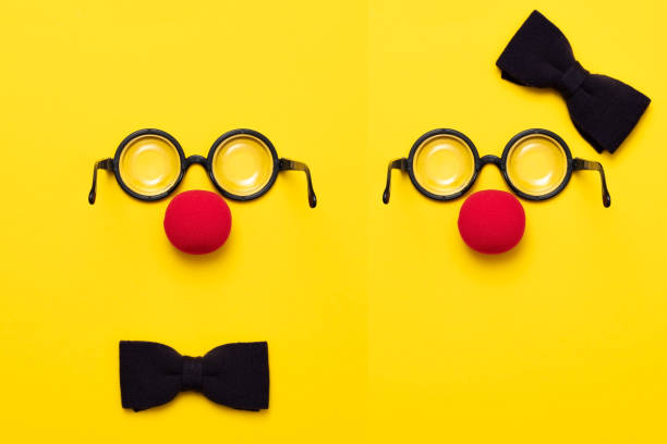забавные очки, красный клоунский нос и галстук лежат на цветном фоне, как лицо. - eyeware стоковые фото и изображения