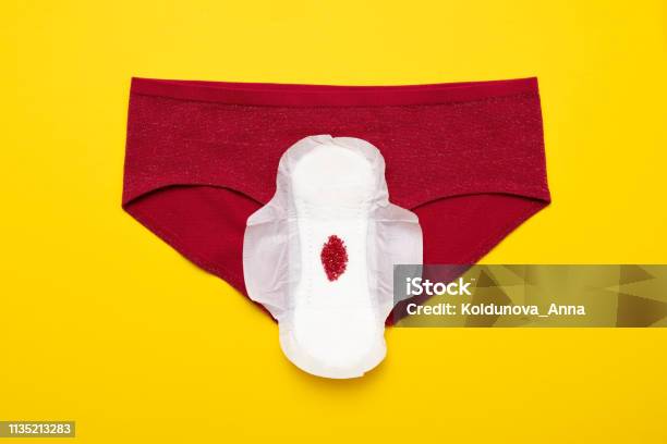 Red Drop From Beads On Pants On Yellow Background Menstruation Period Stock Photo - Download Image Now