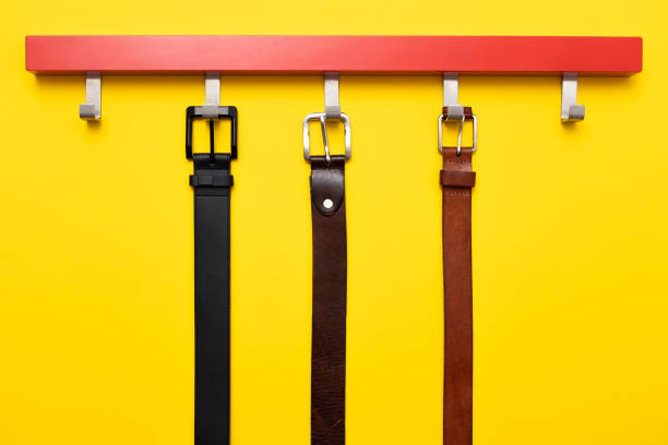 istock Male leather belt on hanger on yellow background. 1135213402