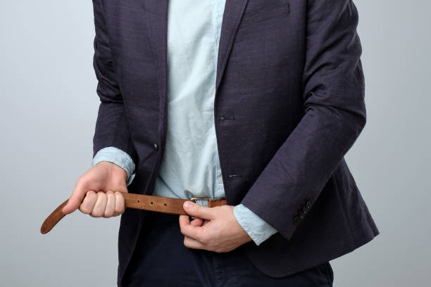 Businessman tightening his belt concept for recession or economic depression Businessman tightening his belt concept for recession or economic depression. Less money concept depression behavior businessman economic depression stock pictures, royalty-free photos & images