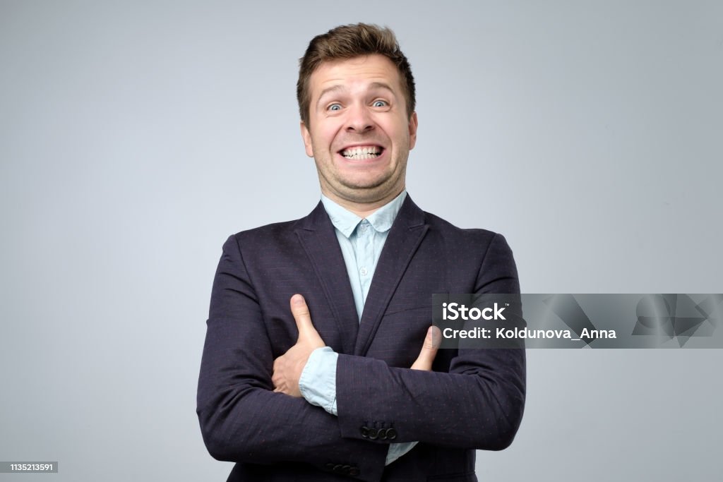 Mature business man laughs from ear to ear, giggles on the funny stories. Mature business man laughs from ear to ear, giggles on the funny stories. False or fake smile. Artificial Stock Photo