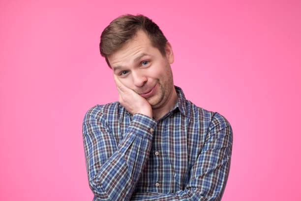 istock Happy funny guy holding palms on cheeks leaning on hands and smiling with affection 1135213927