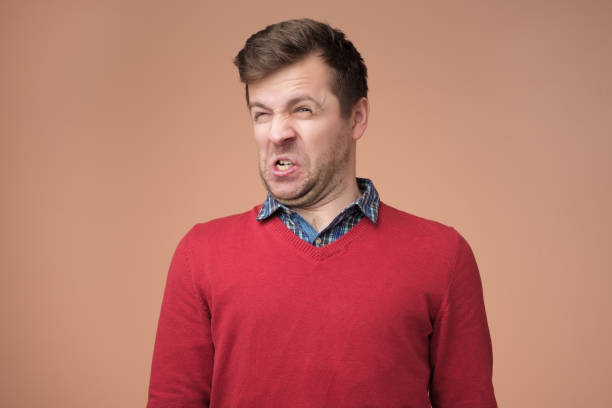 Shocked young man looking at something unpleasant and bad Disguting smell concept. Shocked young man looking at something unpleasant and bad, isolated on gray background. Negative emotion concept gurning stock pictures, royalty-free photos & images