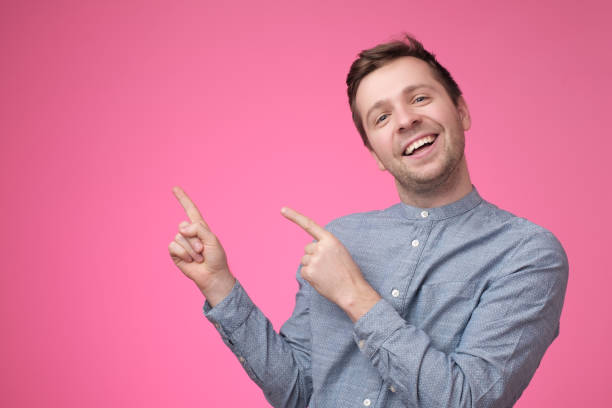 istock Happy handsome guy looking at camera, smiling and pointing aside with hand. 1135214945