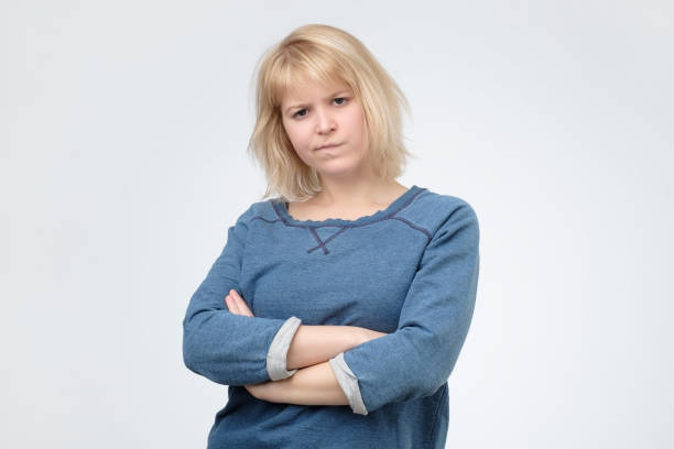 istock Upset unsatisfied blonde woman standing with arms folded 1135215029
