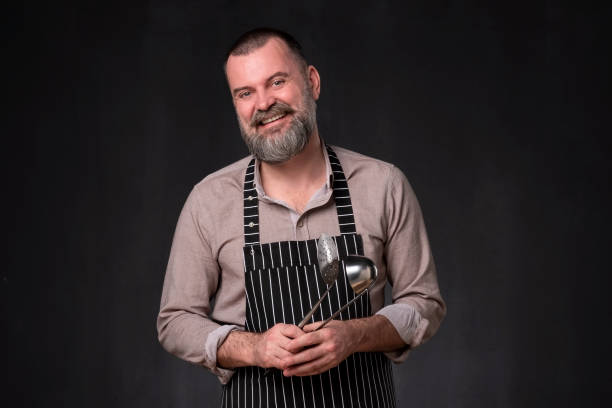 istock Maure bearded man in apron is holding a ladle kitchen. 1135215405