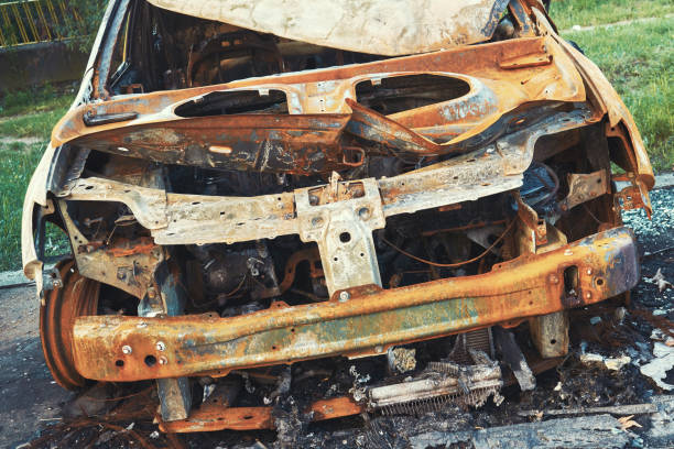 istock A burnt out passenger car that suffered from a violent fire in a public parking lot on a street in a big city. Damaged vehicle surface. Broken windshield. Incident in the parking lot. Front view 1135215535