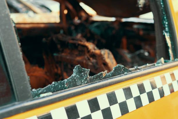 The yellow taxi that has burnt down the car which has suffered from a strong fire in a city parking place in a street in a big city. Damaged vehicle surface. Broken door glass. Incident in the parking el taxi amarillo que ha quemado el coche que ha sufrido de un fuerte incendio en un lugar de estacionamiento de la ciudad en una calle en una gran ciudad. superficie del vehículo dañada. vidrio de la puerta rota. incidente en el estacionamiento