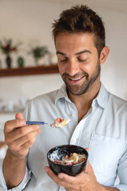 istock Happy man at home eating a parfait for breakfast 1135216522