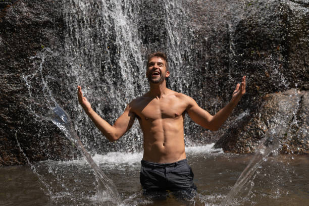 istock Happy male hiker having fun in a waterfall 1135216535