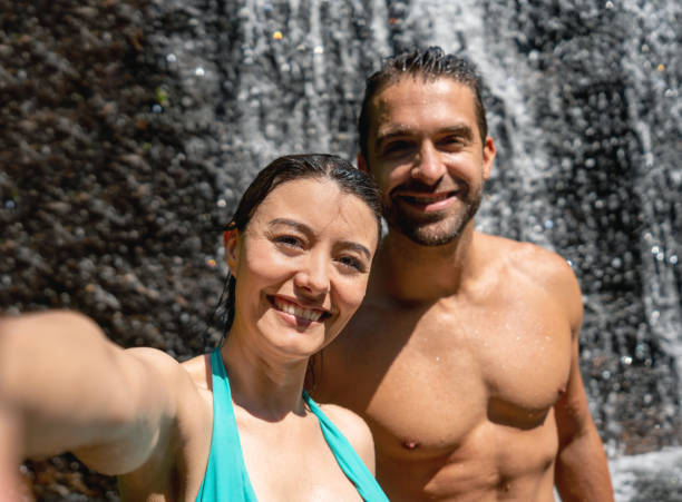 istock Adventurous couple taking a selfie in a waterfall 1135216605