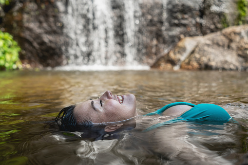 Portrait of a happy woman relaxing and floating in the water â lifestyle concepts