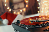 Image of Christmas. Turntable vinyl record player. Sound technology for DJ to mix & play music. Retro audio vinyl record on a background of Christmas decorations
