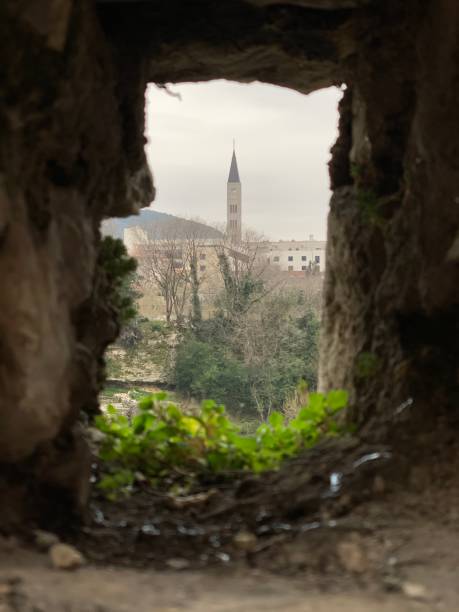 istock Missing Block from Wall after Bosnian war with Catholic Bell Tower in the background 1135219963